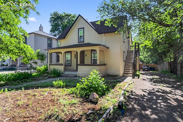 823 N Corona St, Colorado Springs, CO 80903 - view of front facade featuring stucco siding, a porch, and stairway