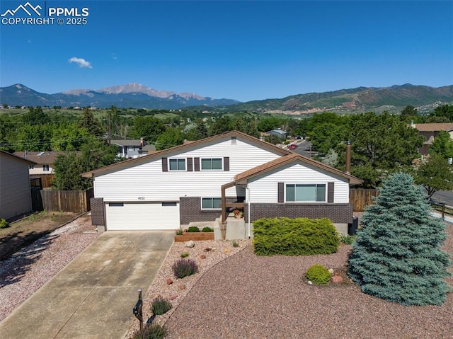 4032 E Darby Cir, Colorado Springs, CO 80907 - view of front of property featuring a mountain view, brick siding, a garage, and driveway