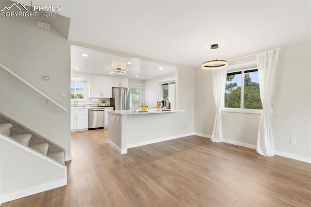 4032 E Darby Cir, Colorado Springs, CO 80907 - kitchen featuring stainless steel appliances, white cabinetry, a peninsula, healthy amount of natural light, and recessed lighting