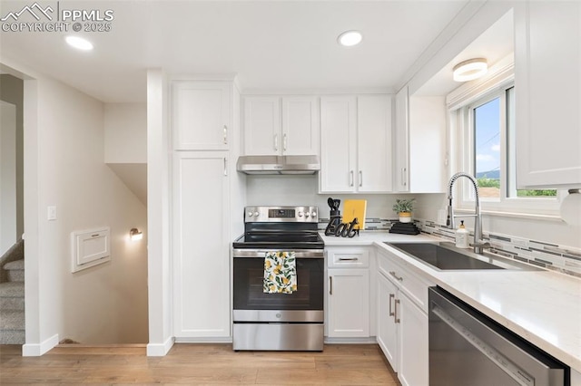 4032 E Darby Cir, Colorado Springs, CO 80907 - kitchen featuring stainless steel appliances, under cabinet range hood, white cabinetry, light wood finished floors, and recessed lighting