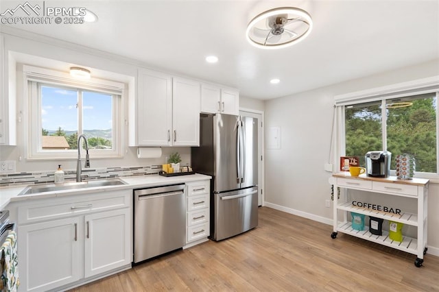 4032 E Darby Cir, Colorado Springs, CO 80907 - kitchen with stainless steel appliances, light countertops, white cabinetry, light wood-style floors, and recessed lighting