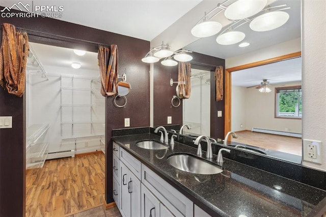 22 Puma Path, Manitou Springs, CO 80829 - bathroom with baseboard heating, wood finished floors, double vanity, a ceiling fan, and a spacious closet