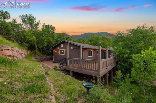 22 Puma Path, Manitou Springs, CO 80829 - back of house at dusk featuring a deck with mountain view
