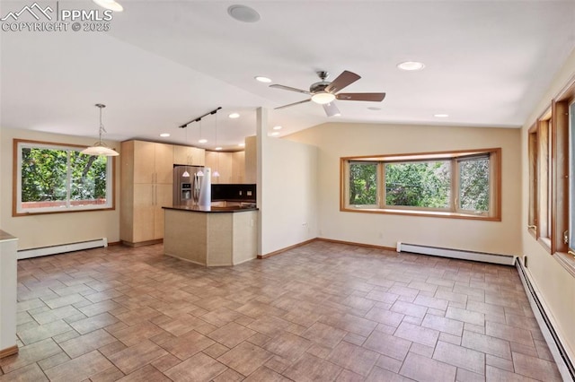 22 Puma Path, Manitou Springs, CO 80829 - kitchen featuring stainless steel fridge, baseboard heating, dark countertops, a baseboard radiator, and lofted ceiling