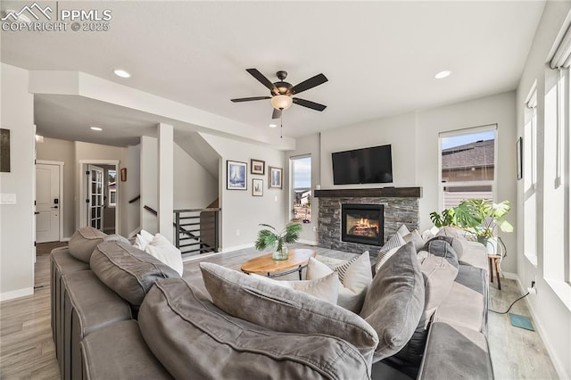 5446 Mesa Top Dr, Monument, CO 80132 - living area with light wood-style flooring, stairway, a stone fireplace, ceiling fan, and recessed lighting