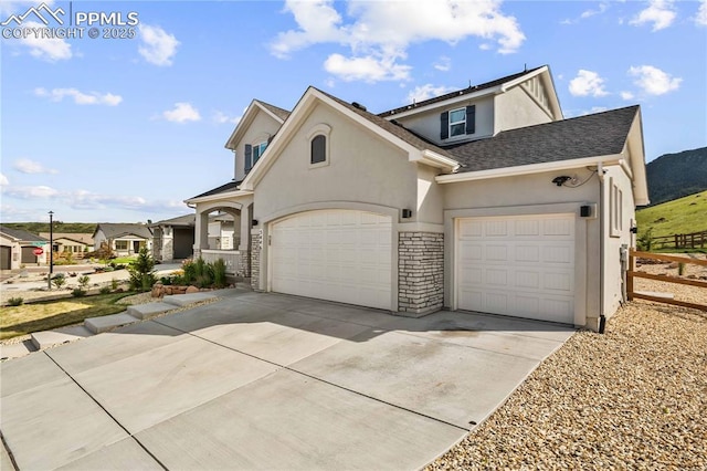 5446 Mesa Top Dr, Monument, CO 80132 - view of front facade featuring stucco siding, a garage, driveway, and roof with shingles
