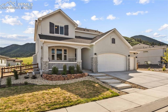 5446 Mesa Top Dr, Monument, CO 80132 - view of front of home featuring covered porch, a mountain view, stucco siding, driveway, and stone siding