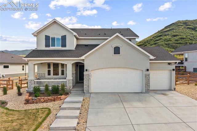 5446 Mesa Top Dr, Monument, CO 80132 - view of front of home with a porch, stucco siding, a mountain view, a garage, and stone siding