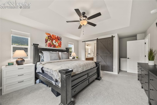 5446 Mesa Top Dr, Monument, CO 80132 - bedroom featuring a raised ceiling, a barn door, light colored carpet, ensuite bathroom, and ceiling fan