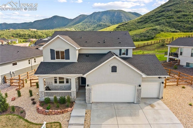 5446 Mesa Top Dr, Monument, CO 80132 - view of front of house featuring a porch, a garage, driveway, a mountain view, and stucco siding