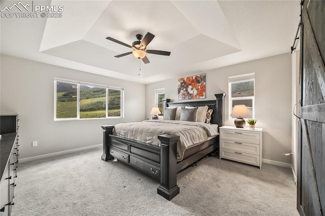 5446 Mesa Top Dr, Monument, CO 80132 - bedroom featuring a raised ceiling, carpet flooring, a barn door, and ceiling fan