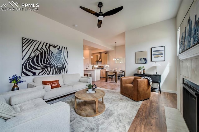 2186 Keara Hts, Colorado Springs, CO 80919 - living area featuring ceiling fan, light wood-style floors, and a tile fireplace