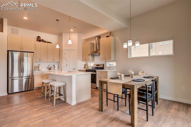 2186 Keara Hts, Colorado Springs, CO 80919 - kitchen featuring stainless steel appliances, wall chimney exhaust hood, a breakfast bar area, light wood finished floors, and decorative backsplash