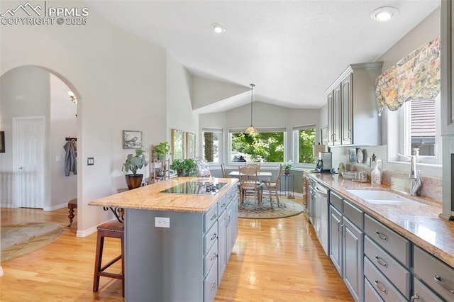 1690 Doe Run Pt, Colorado Springs, CO 80919 - kitchen with gray cabinetry, black electric stovetop, a kitchen breakfast bar, light wood-style flooring, and a center island