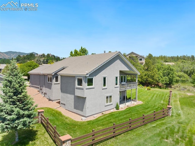 1690 Doe Run Pt, Colorado Springs, CO 80919 - rear view of house featuring a balcony, stucco siding, and a tile roof