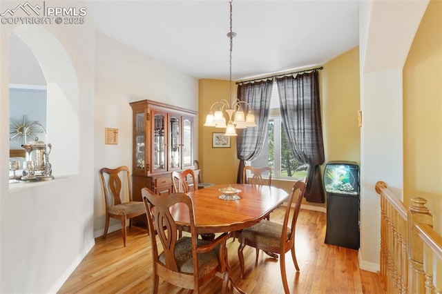 1690 Doe Run Pt, Colorado Springs, CO 80919 - dining room with light wood-style flooring, a chandelier, and arched walkways