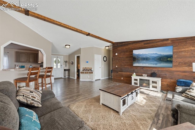 5664 Southfork Dr, Peyton, CO 80831 - living area featuring wood walls, wood finished floors, and arched walkways