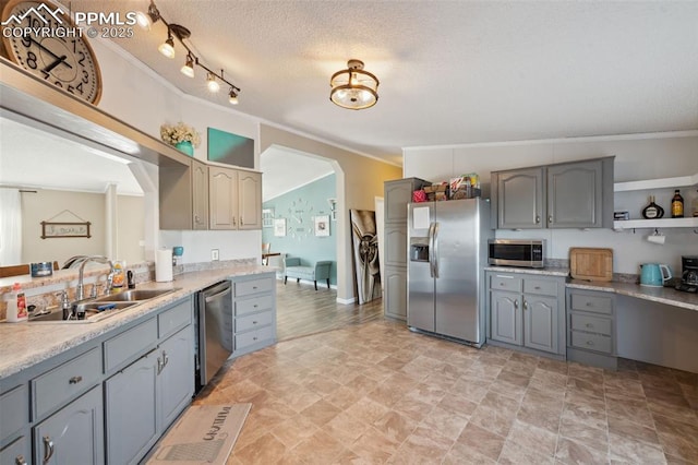 5664 Southfork Dr, Peyton, CO 80831 - kitchen featuring stainless steel appliances, gray cabinetry, ornamental molding, light countertops, and a textured ceiling