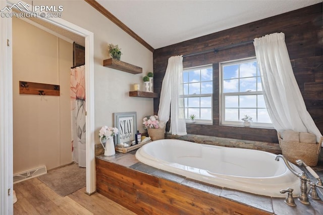 5664 Southfork Dr, Peyton, CO 80831 - bathroom featuring ornamental molding, a bath, wood finished floors, and vaulted ceiling