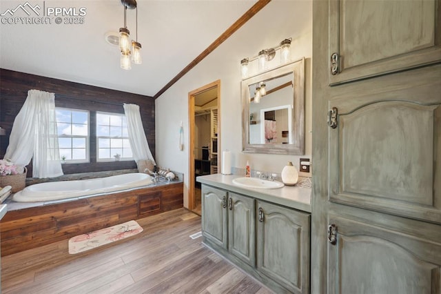 5664 Southfork Dr, Peyton, CO 80831 - full bath with lofted ceiling, vanity, a bath, wood finished floors, and ornamental molding