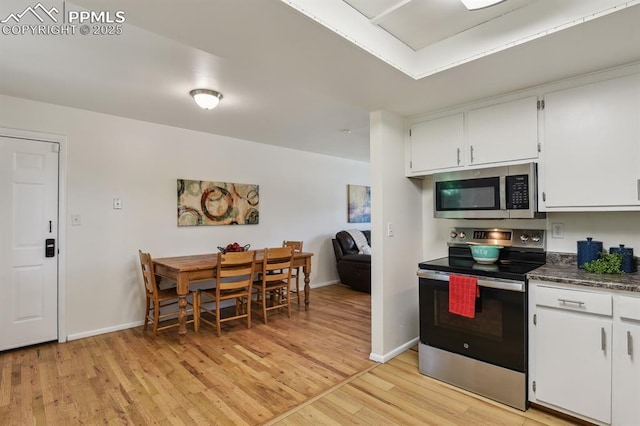 906 Bowser Dr, Colorado Springs, CO 80909 - kitchen featuring appliances with stainless steel finishes, light wood finished floors, white cabinetry, and dark countertops