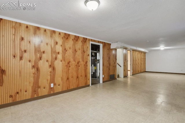 906 Bowser Dr, Colorado Springs, CO 80909 - unfurnished room featuring wooden walls, stairs, and a textured ceiling