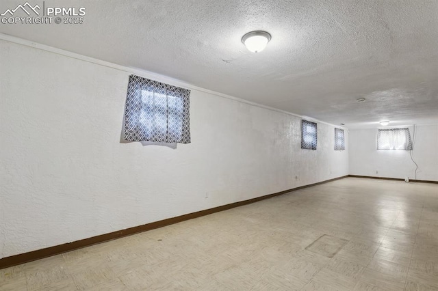 906 Bowser Dr, Colorado Springs, CO 80909 - below grade area with tile patterned floors, a textured ceiling, healthy amount of natural light, and a textured wall