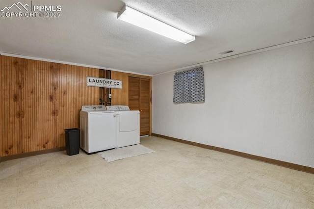 906 Bowser Dr, Colorado Springs, CO 80909 - washroom with separate washer and dryer, light floors, a textured ceiling, and wooden walls