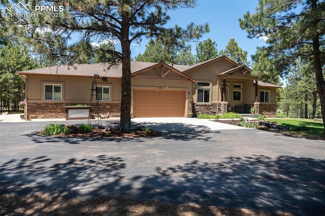 15324 Pole Pine Pt, Colorado Springs, CO 80908 - view of front of home featuring stone siding, stucco siding, an attached garage, and concrete driveway