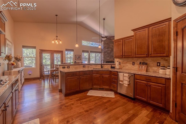 15324 Pole Pine Pt, Colorado Springs, CO 80908 - kitchen with stainless steel dishwasher, plenty of natural light, high vaulted ceiling, dark wood-type flooring, and brown cabinets