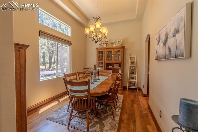 15324 Pole Pine Pt, Colorado Springs, CO 80908 - dining area featuring arched walkways, wood finished floors, healthy amount of natural light, and a towering ceiling