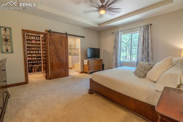 15324 Pole Pine Pt, Colorado Springs, CO 80908 - bedroom with a raised ceiling, carpet flooring, a walk in closet, a barn door, and connected bathroom