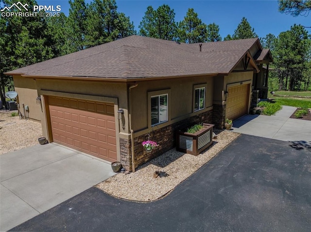 15324 Pole Pine Pt, Colorado Springs, CO 80908 - view of front of house featuring stone siding, stucco siding, an attached garage, and a shingled roof