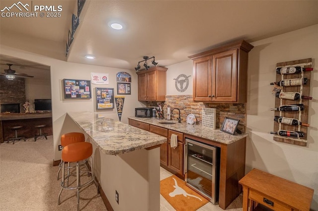 15324 Pole Pine Pt, Colorado Springs, CO 80908 - bar area featuring wine cooler, a ceiling fan, tasteful backsplash, black microwave, and light colored carpet