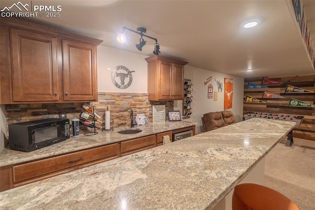 15324 Pole Pine Pt, Colorado Springs, CO 80908 - kitchen featuring black microwave, light stone counters, backsplash, and brown cabinetry