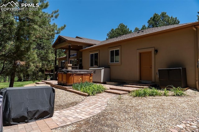 15324 Pole Pine Pt, Colorado Springs, CO 80908 - back of property featuring a hot tub, stucco siding, and a patio area