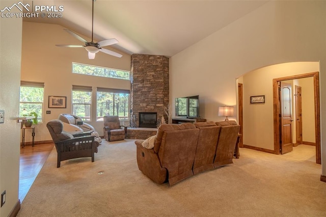 15324 Pole Pine Pt, Colorado Springs, CO 80908 - living area featuring high vaulted ceiling, light colored carpet, a ceiling fan, a stone fireplace, and arched walkways