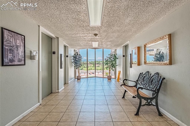 411 Lakewood Cir Unit B527, Colorado Springs, CO 80910 - corridor featuring a textured ceiling, expansive windows, light tile patterned floors, and a textured wall