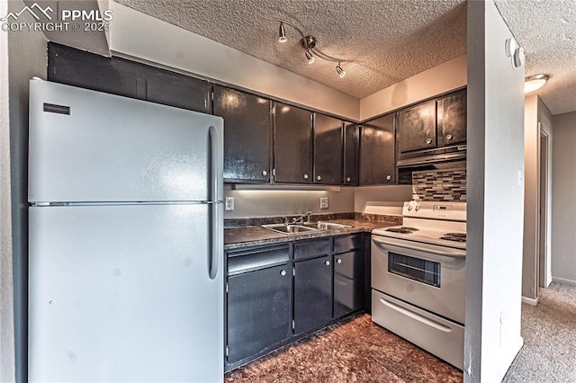 411 Lakewood Cir Unit B527, Colorado Springs, CO 80910 - kitchen featuring white appliances, dark countertops, a textured ceiling, and under cabinet range hood
