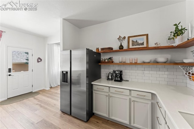 1773 Herd St, Colorado Springs, CO 80910 - kitchen featuring stainless steel fridge with ice dispenser, open shelves, tasteful backsplash, and light wood-type flooring