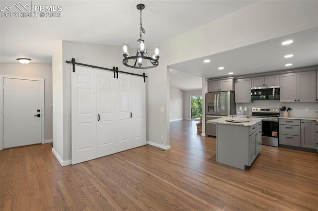 110 Fox Hill Ln, Colorado Springs, CO 80919 - kitchen featuring stainless steel appliances, gray cabinets, a barn door, a chandelier, and dark wood-type flooring