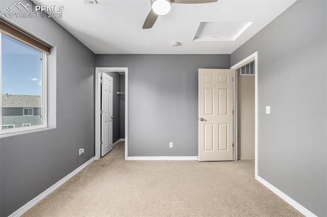 5718 Badenoch Ter, Colorado Springs, CO 80923 - unfurnished bedroom with light carpet, a spacious closet, attic access, a ceiling fan, and a closet