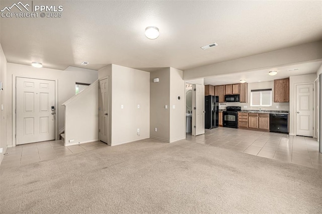 5718 Badenoch Ter, Colorado Springs, CO 80923 - unfurnished living room with light colored carpet, light tile patterned flooring, and stairway