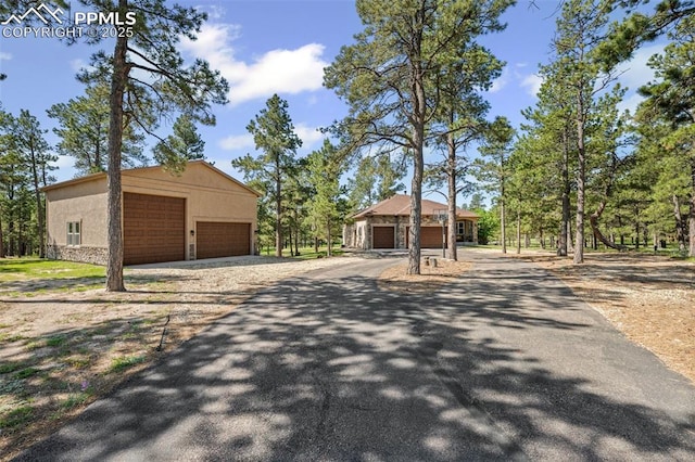 15704 Pole Pine Pt, Colorado Springs, CO 80908 - view of front of property featuring a garage, an outbuilding, stucco siding, and stone siding
