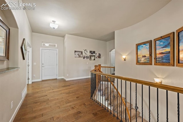 15704 Pole Pine Pt, Colorado Springs, CO 80908 - hall featuring wood-type flooring, an upstairs landing, and arched walkways