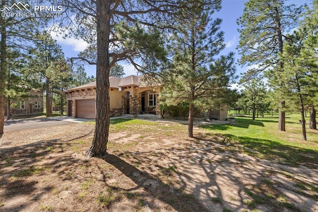 15704 Pole Pine Pt, Colorado Springs, CO 80908 - view of front of house with a garage, driveway, stone siding, stucco siding, and a front lawn