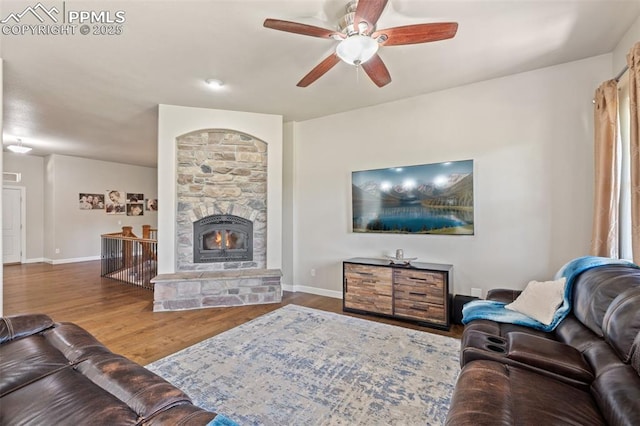 15704 Pole Pine Pt, Colorado Springs, CO 80908 - living area with ceiling fan, wood finished floors, and a stone fireplace