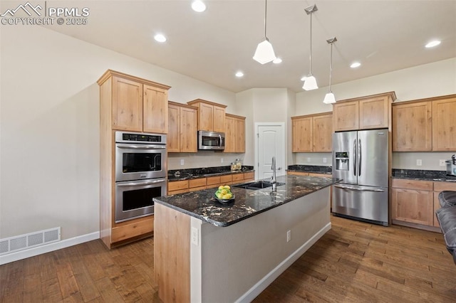 15704 Pole Pine Pt, Colorado Springs, CO 80908 - kitchen featuring stainless steel appliances, dark wood-style floors, a center island with sink, dark stone counters, and pendant lighting