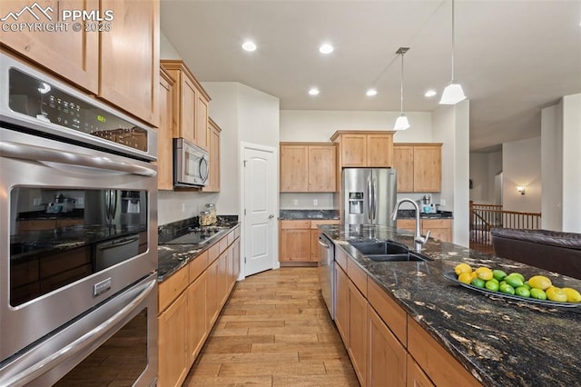 15704 Pole Pine Pt, Colorado Springs, CO 80908 - kitchen featuring appliances with stainless steel finishes, light wood-type flooring, decorative light fixtures, dark stone counters, and recessed lighting