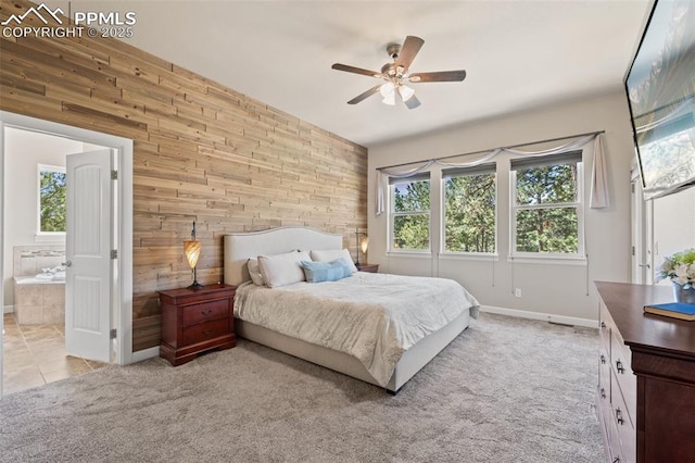 15704 Pole Pine Pt, Colorado Springs, CO 80908 - bedroom featuring wooden walls, ensuite bathroom, a ceiling fan, light tile patterned flooring, and light colored carpet